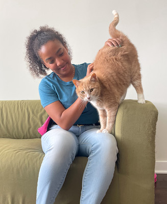 Trainer with cat on her lap on couch cute